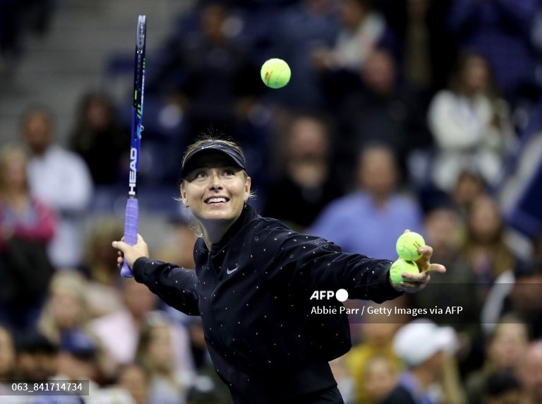 Maria Sharapova mengirimkan bola tenis bertanda tangan ke tribun penonton setelah kemenangannya atas Sofia Kenin pada pertandingan tunggal putri putaran ketiga pada Hari Kelima AS Terbuka 2017 di USTA Billie Jean King National Tennis Center di New York City. 